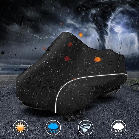 Black motorcycle cover on a dark road with stormy sky
